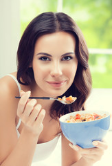 Cheerful beautiful young woman eating muslin