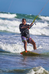 Athletic man jump on kite surf board sea waves