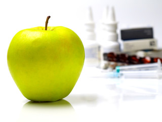fresh ripe apple in front of medication, shallow depth of field