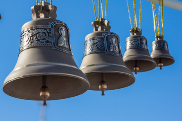 Fototapeta premium Bronze bells different sizes on a background of the sky
