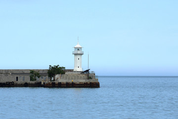 Beacon mounted on the edge of the concrete pier at the port of Yalta, which partially block off the entrance to Yalta Bay
