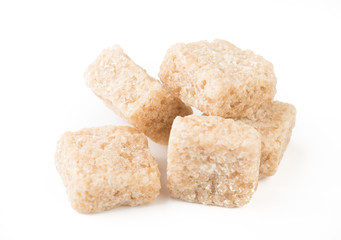 pieces of brown cane sugar isolated on white background.