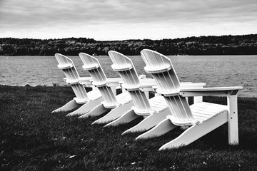 Adirondack chairs in a row by the lakeshore