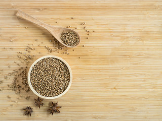 Coriander seeds in wooden bowl and on wooden board.( Space and composition for text )