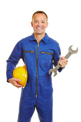 Mechanic in jumpsuit with helmet and jaw wrench - obrazy, fototapety, plakaty
