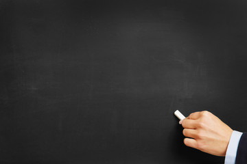Fototapeta premium Hand with chalk on blackboard