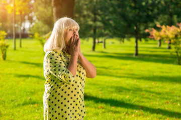 Scared senior woman. Female covers mouth with hands. Witness of an accident. Horror and shock.