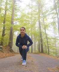 Obraz premium Energetic young woman do exercises outdoors in park to keep their bodies in shape. Fitness concept. Body-building theme. Sport mood.