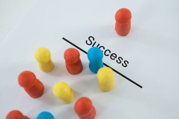 Multicolored figurines on a paper with text success