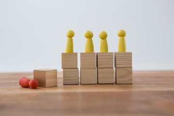 Yellow Figurines on wooden blocks in a row 