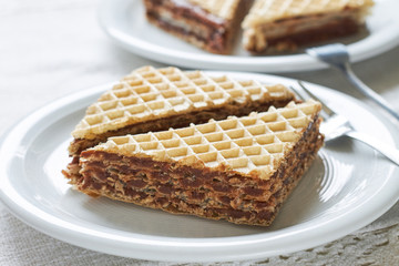 Wafer sheets filled with caramelized sugar and hazelnut cream served on white plate