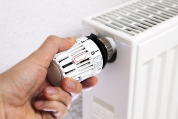 Hand adjusting the temperature by thermostat. High (warm) temperature setting.