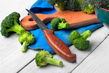 wet knife and brocolli on the cutting board with on the white wooden table.copy space.selective focus