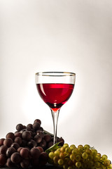 glass of red grapes on a light background