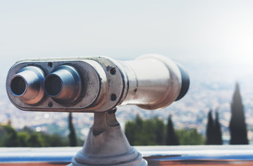 Touristic telescope look at the city with view of Barcelona Spain, close up old metal binoculars on background viewpoint overlooking the mountain, hipster coin operated in panorama observation, mockup