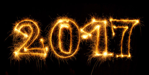 Happy New Year made by sparklers on black background