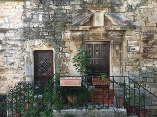 Fototapeta na wymiar façade en pierre d'une ancienne maison de village médiéval de style vielle demeure 