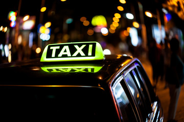 Taxi sign on the roof of a taxi car at night