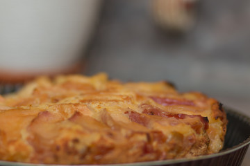 Apple pie on the plate. Golden crust. The interior of the kitchen.