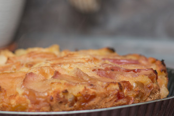 Apple pie on the plate. Golden crust. The interior of the kitchen.
