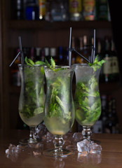 Three glasses of mojito on the background of a bar cafe