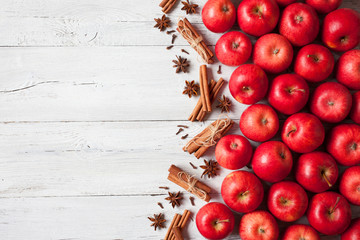 Wooden background with red apples and spices