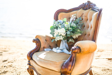 Fototapeta na wymiar Beautiful bouquet for wedding ceremony in a chair on the shore of a sea
