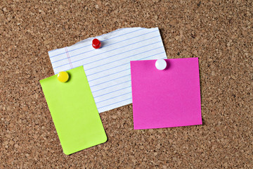 Three colorful blank notes on corkboard