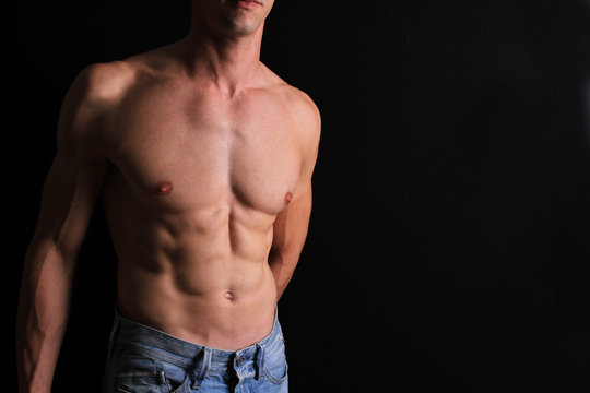 Strong attractive muscular Man, male body, torso, hair removal, six pack abs over black background, copy space
