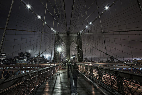 Ghost like figure on Brooklyn Bridge at night