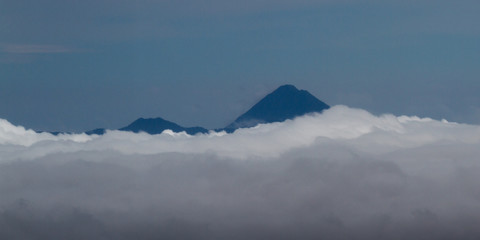 Fototapeta na wymiar Arenal Volcano peaking thru the clouds