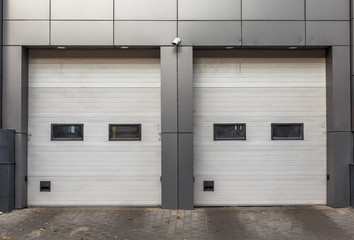 Two white garage doors. Sectional lift gates.