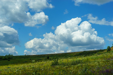 Bright blue sky with high clouds, natural scenery, the road on the hill