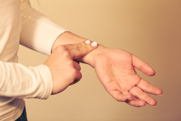 Woman checking pulse on wrist closeup
