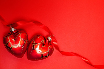 Pair of Christmas balls on red ribbon on red background. Christmas decoration. Christmas card. Xmas. Love's style.