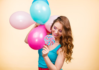 Woman with colorful balloons and lollipop