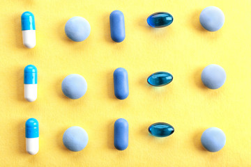 Heap of pills on yellow background