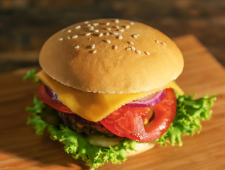 Big tasty hamburger on wooden board