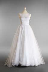 Fototapeta na wymiar Made-up wedding dress on mannequin against grey background