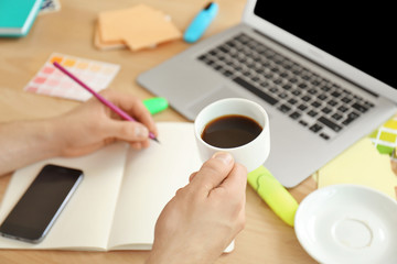 Man holding cup of coffee, close up