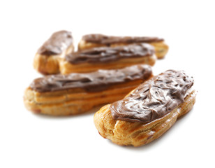 Delicious eclairs with chocolate in a row on white background