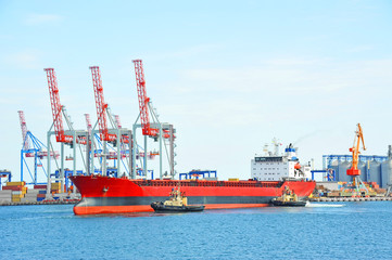 Fototapeta premium Tugboat assisting bulk cargo ship