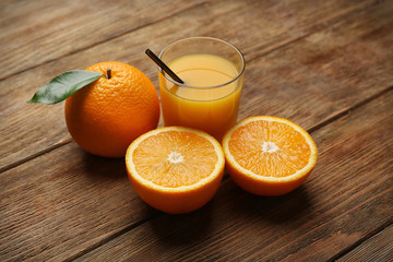 Oranges with juice on wooden table