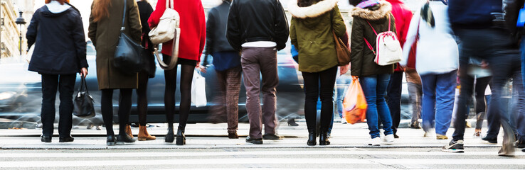 people waiting at the pedestrian crossing