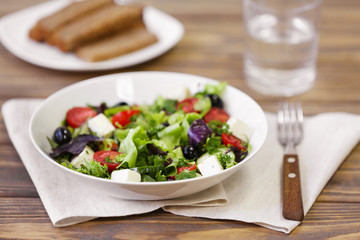 Fresh delicious salad on wooden background, closeup