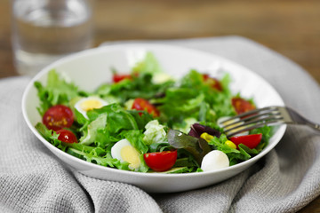 Plate of fresh delicious salad on napkin, closeup