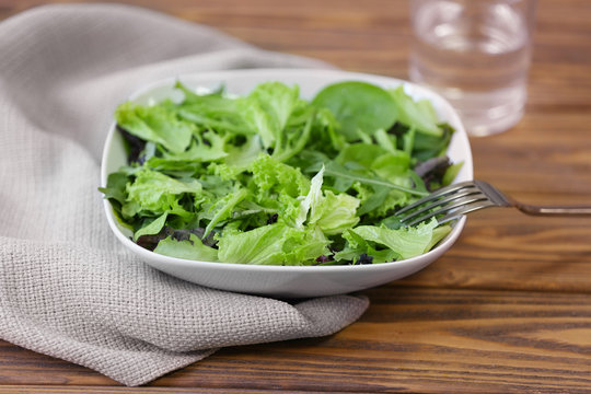 Fresh delicious salad on wooden background, closeup
