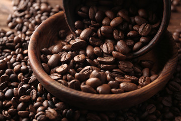 Bowls with coffee beans on wooden background, close up view
