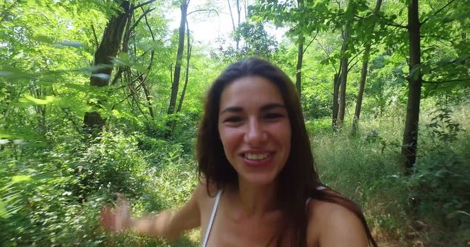 A woman surrounded by greenery you take pictures and talk to the camera and greets the people with whom it is to smart-phone