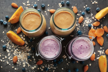 Mason jars with smoothie and some ingredients on grey table